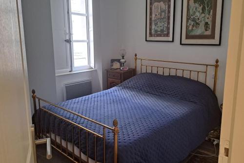 une chambre avec un lit avec une couette bleue et une fenêtre dans l'établissement Le Marquis - Centre historique - 3 chambres, à Avignon