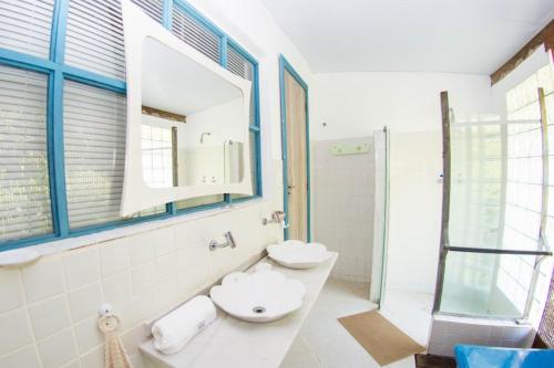 a bathroom with two sinks and a mirror at Casa Grande Flats in Abraão