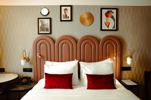 a bedroom with a large bed with two red pillows at Hotel Indigo Belgrade, an IHG Hotel in Belgrade