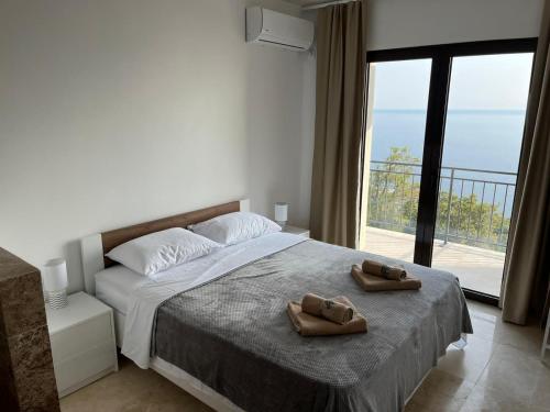 a bedroom with a bed with two brown shoes on it at Family Vacation Villa Rezevici in Budva