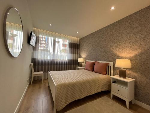 une petite chambre avec un lit et un miroir dans l'établissement Alta Lisboa Apartment, à Lisbonne