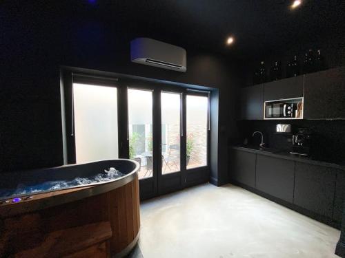 a kitchen with a tub and a large window at La Shelby avec terrasse privée in Bordeaux