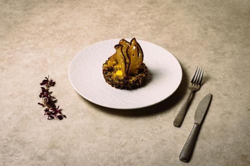 a plate with a piece of cake on a table with a fork and knife at Links House at Royal Dornoch in Dornoch