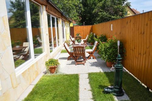 een patio met een tafel en stoelen en een hek bij Blueline Motel in Jászberény