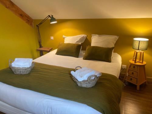 a bedroom with a large bed with two baskets on it at Chez Jeanmyvonne in La Bresse
