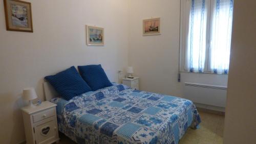 a bedroom with a blue bed and a window at Al 12 in Marina di Pisa