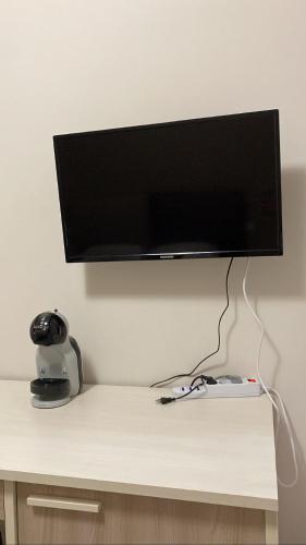a flat screen tv on a wall above a desk at Anema e Core Pizzo in Pizzo