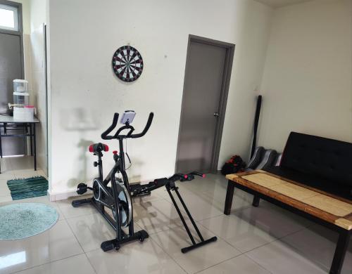 ein Zimmer mit einem Fitnessraum mit einem Laufband und einer Bank in der Unterkunft homestay sayangku islam in Segamat