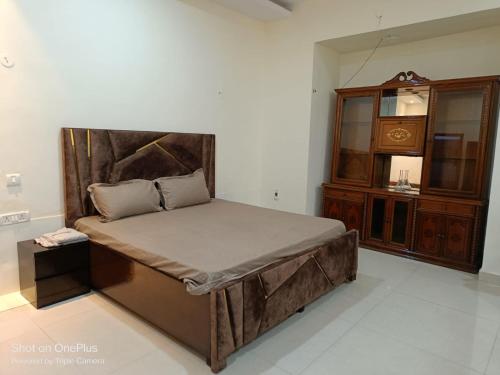 a bedroom with a large bed and a dresser at Heritage home in Cannaught Place in New Delhi