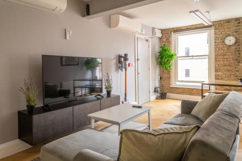 a living room with a couch and a table at City Air Apartments - HATTON GARDEN - GREAT TRANSPORT LINKS in London