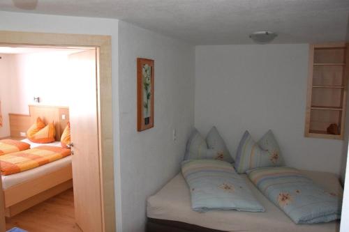 ニーデラウにあるLeitnerhofのソファ、枕、ベッドが備わる客室です。