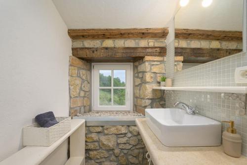 a bathroom with a sink and a stone wall at Villa Zamarija by IstriaLux in Ripenda Kras