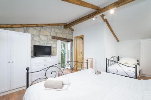 a bedroom with a white bed and a tv at Villa Zamarija by IstriaLux in Ripenda Kras