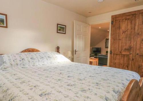 a bedroom with a large bed with a wooden door at Willow cottage with private hot tub in Upper Hulme