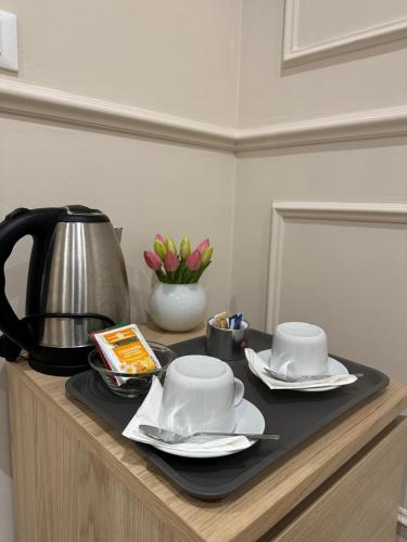 a table with two cups and a tea pot on it at NLM Boutique Suites in Rome
