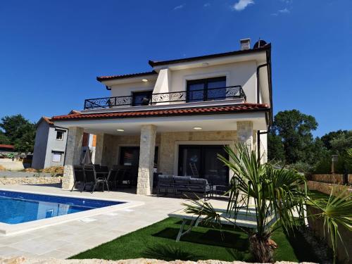 a villa with a swimming pool and a house at Luxury Villa Laura in Malinska
