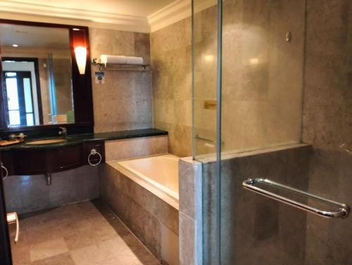 a bathroom with a shower with a tub and a sink at SAMI APARTMENT - Times Square KL in Kuala Lumpur