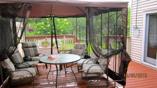 un patio con mesa y sillas en una terraza en West Gate Bed and Breakfast, en Gananoque