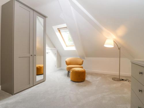 an attic room with a skylight and a chair at Apartment 16 in Y Felinheli