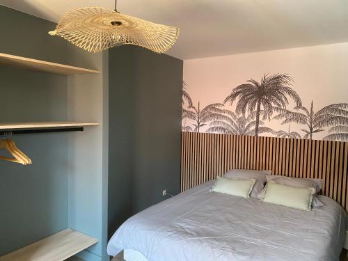 - une chambre avec un lit orné d'une fresque murale de palmiers dans l'établissement Appartement Centre Annecy 100m du lac, à Annecy