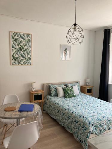 une petite chambre avec un lit et une table dans l'établissement Élégant studio rénové, à Boulogne-sur-Mer