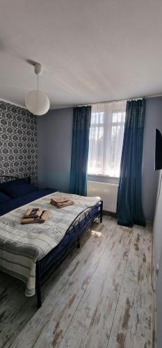 - une chambre dotée d'un lit avec des murs bleus et des rideaux bleus dans l'établissement Apartament Leopard, à Bydgoszcz