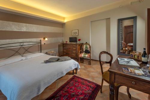 a bedroom with a bed and a table and a desk at Agriturismo Cascina Monchiero in Bra