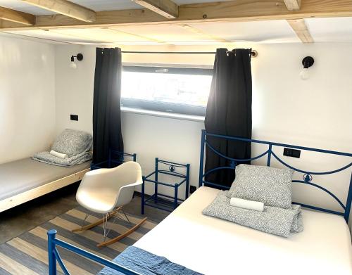 a bedroom with two bunk beds and a chair at Hostel PrzyMorze in Gdańsk