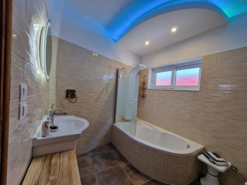 La salle de bains est pourvue d'une baignoire et d'un lavabo. dans l'établissement Crystal Villa, à Skopelos