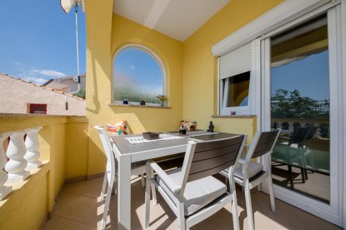 comedor con mesa y sillas en el balcón en Casa Surya - Apartments with sea view and swimming pool en Barbat na Rabu