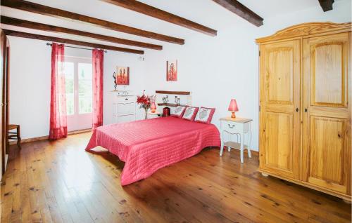 een slaapkamer met een roze bed en houten vloeren bij Lovely Home In Grillon With Wifi in Grillon