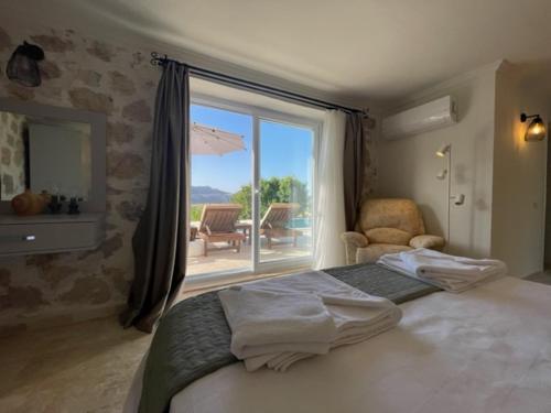 a bedroom with a bed and a large window at Bezirgan Inn Kalkan in Islamlar