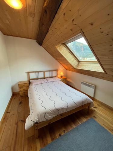 een slaapkamer met een groot bed op zolder bij The Stable House Bourg d’Oisans -bike/hike/ski in Le Bourg-dʼOisans