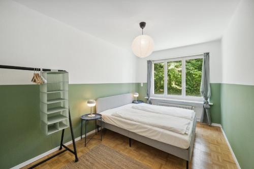 ein Schlafzimmer mit grünen und weißen Wänden und einem Bett in der Unterkunft Bethaniaweg in Rüschlikon