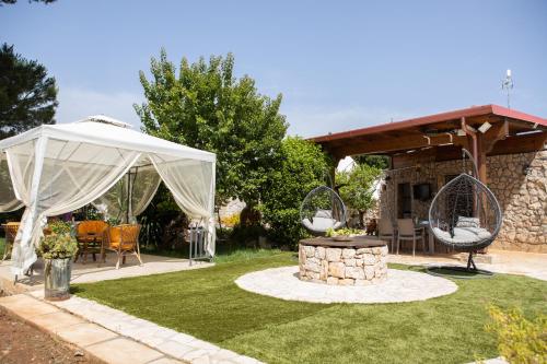 a garden with a white canopy and a table and chairs at trullo nonna netta con piscina idromassaggio e area giochi in Ceglie Messapica