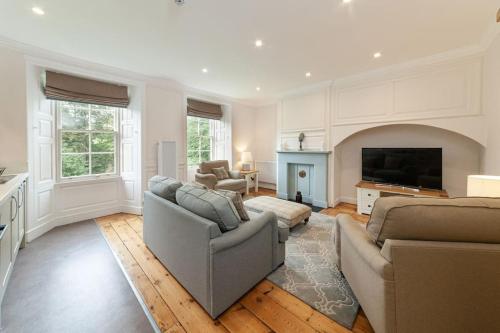 a living room with two couches and a television at Beautiful Grade II Listed Apartments Sleeping 20 in Hexham