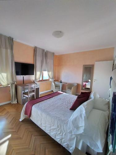 a bedroom with a large bed and a desk at Hotel Astoria in Fermo