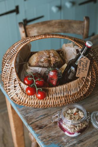 a basket of food and a bottle of wine on a table at Outbuildings Dorset in Bridport