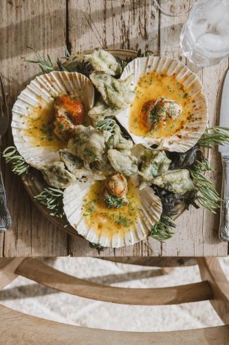 a plate of food with oysters on a wooden table at Outbuildings Dorset in Bridport