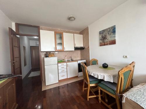 una piccola cucina e una sala da pranzo con tavolo e sedie di Apartment Sara a Podgorica