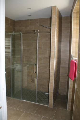 La salle de bains est pourvue d'une douche avec une porte en verre. dans l'établissement Maison tout confort pour 4 à 6 dans village paisible, à Argenteuil-sur-Armançon
