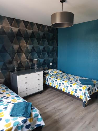 a bedroom with two beds and a dresser in it at Maison tout confort - Les Gîtes du Loup Garmand in Argenteuil-sur-Armançon