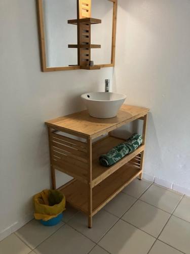 uma casa de banho com um lavatório e um espelho em La Kallina em Grand-Bourg