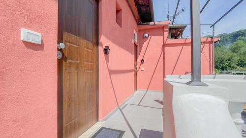 a pink building with a wooden door on the side at Lo Scorcio Marmore in Belvedere Inferiore