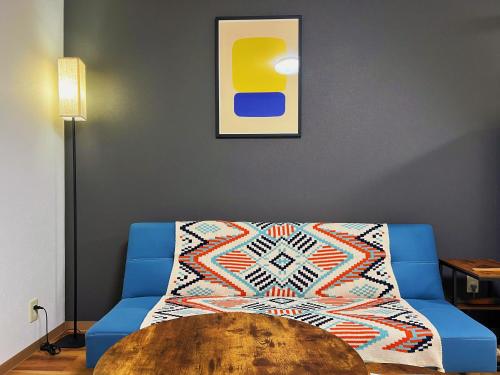 a living room with a blue couch and a table at 市中山居 中崎町駅3分鐘 大阪駅 梅田商圈 關西機場直達 3階日式傳統町屋 獨享110平超大空間 in Osaka