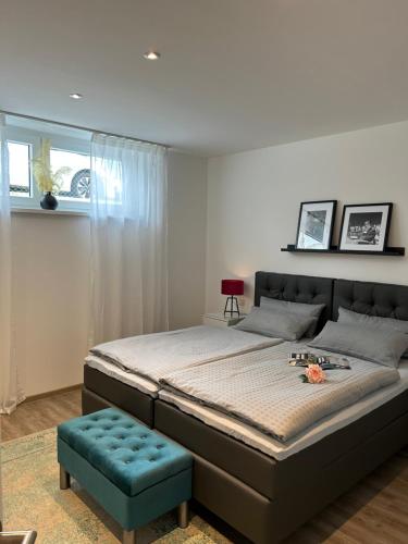 ein Schlafzimmer mit einem großen Bett und einem blauen Stuhl in der Unterkunft Premium Ferienwohnung im Herzen der Kurstadt in Bad Neuenahr-Ahrweiler