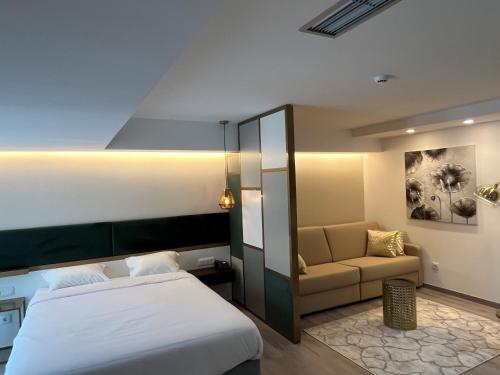 a hotel room with a bed and a couch at Hotel 4 Estações in Fátima