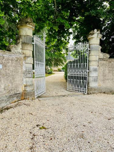 an open gate to a garden with a driveway at Le Château de Leugny in Oiron