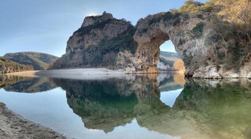 a large body of water with an arch in the middle at Villa Les Romarins in Vallon-Pont-dʼArc
