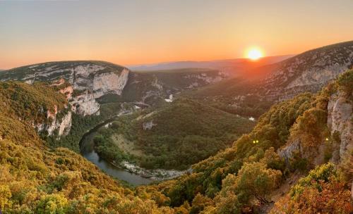 a view of a mountain valley with a river at sunset at Villa Les Romarins in Vallon-Pont-dʼArc